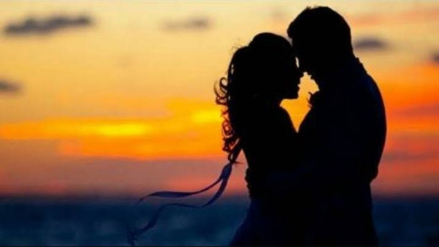 Silhouette of a man and woman in love, holding each other against a sunset backdrop, symbolizing their unbreakable bond and detachment from the world.
