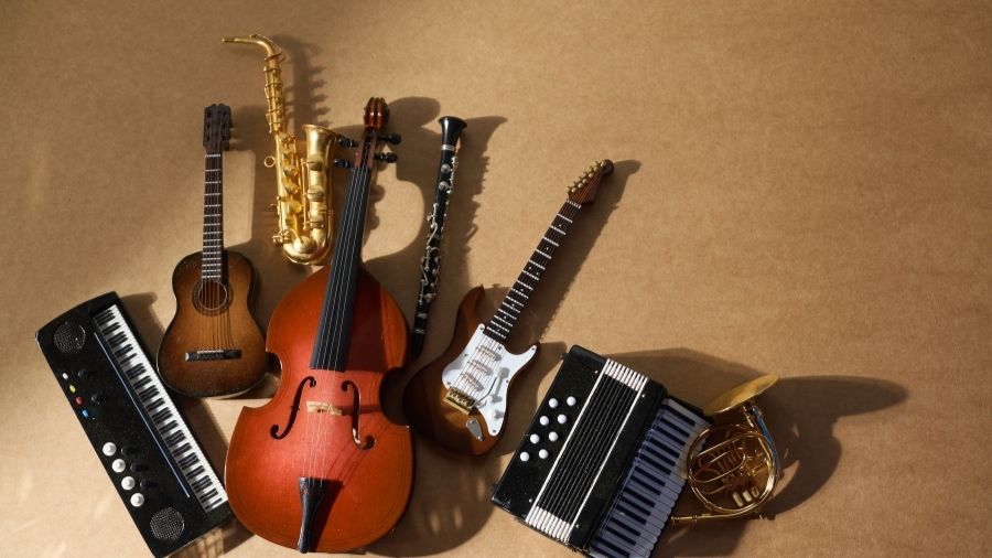 Assortment of world music instruments displayed on a brown background, with soft shadows adding depth and texture.