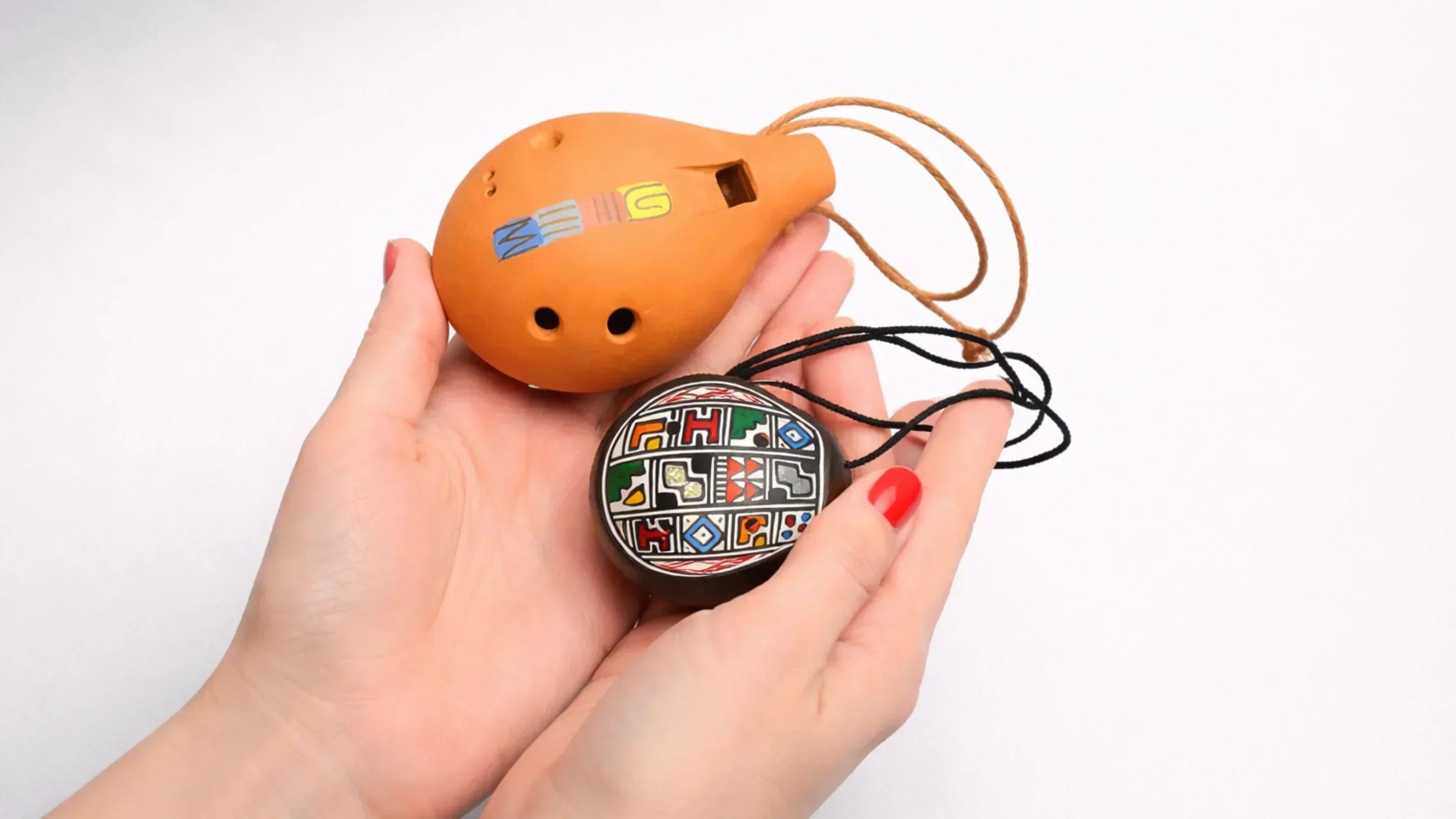 woman hands holding small and large ocarina
