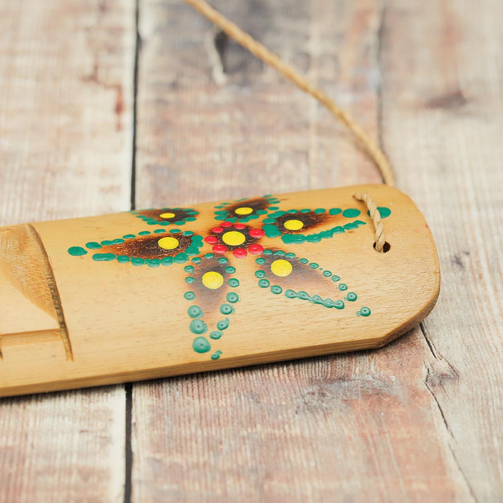 Close-up of the bamboo Rumbai guiro, showcasing the vibrant hand-painted colourful design