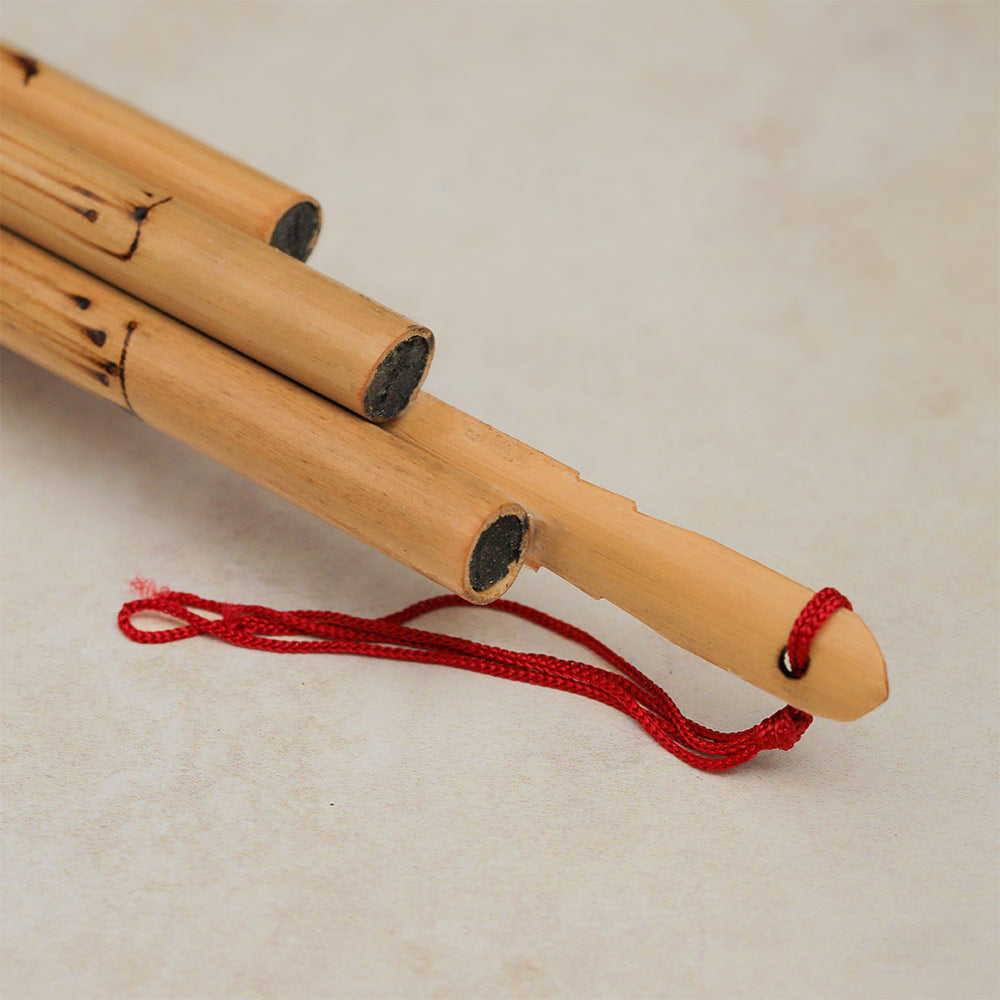 Close-up of the bamboo Thai Wot flute, highlighting its detail and attached string.