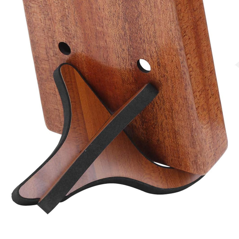 Close-up of the back of a Gecko wooden kalimba on a display stand, showing the sound holes and the back of the stand with its detailed wood finish.