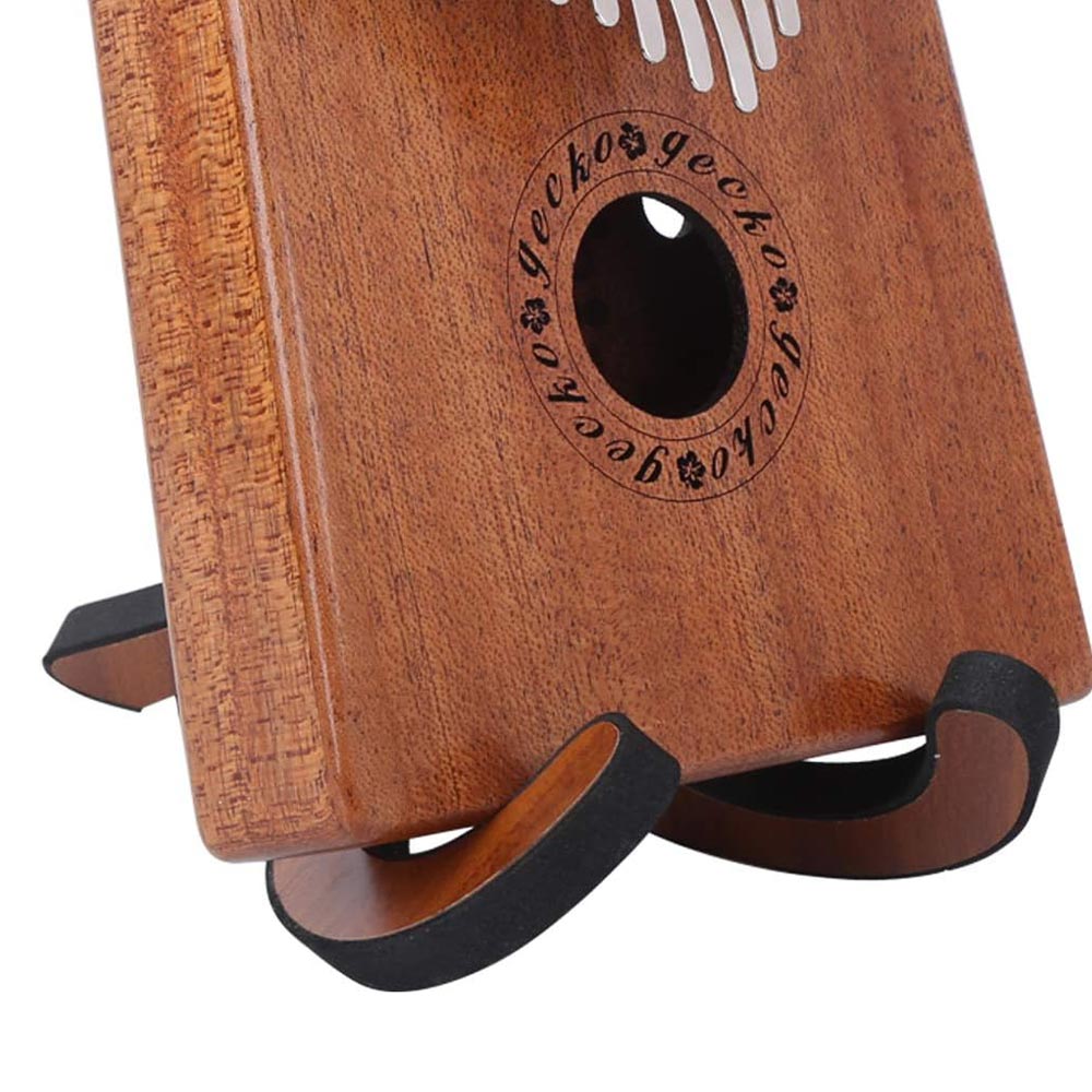 Close-up of a Gecko wooden kalimba placed on a display stand, showing the detailed wood texture and key arrangement.