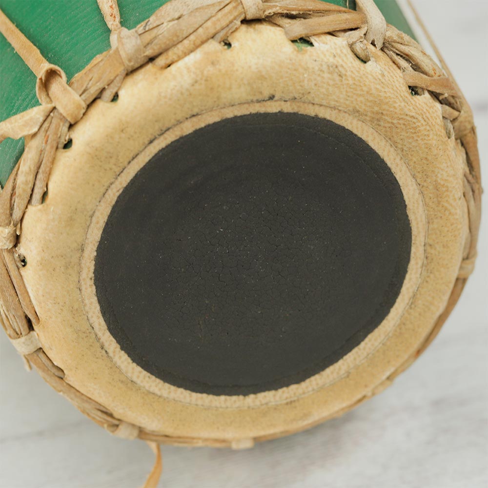 Close-up of the syahi, the central black tuning spot on the green Nepalese Madal drum head.