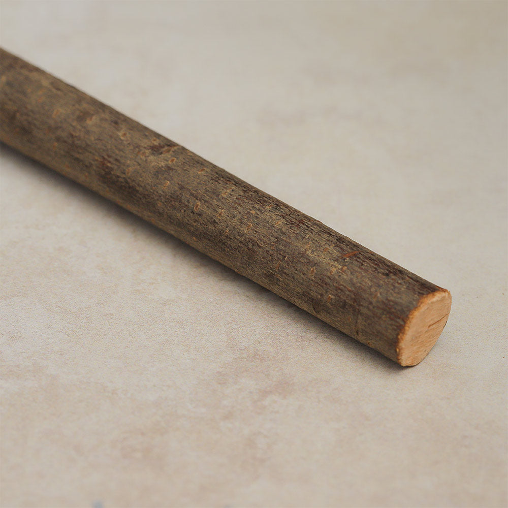 Close-up of the wooden stick handle of the Khenji shamanic shaker, showcasing its smooth texture and natural wood grain.