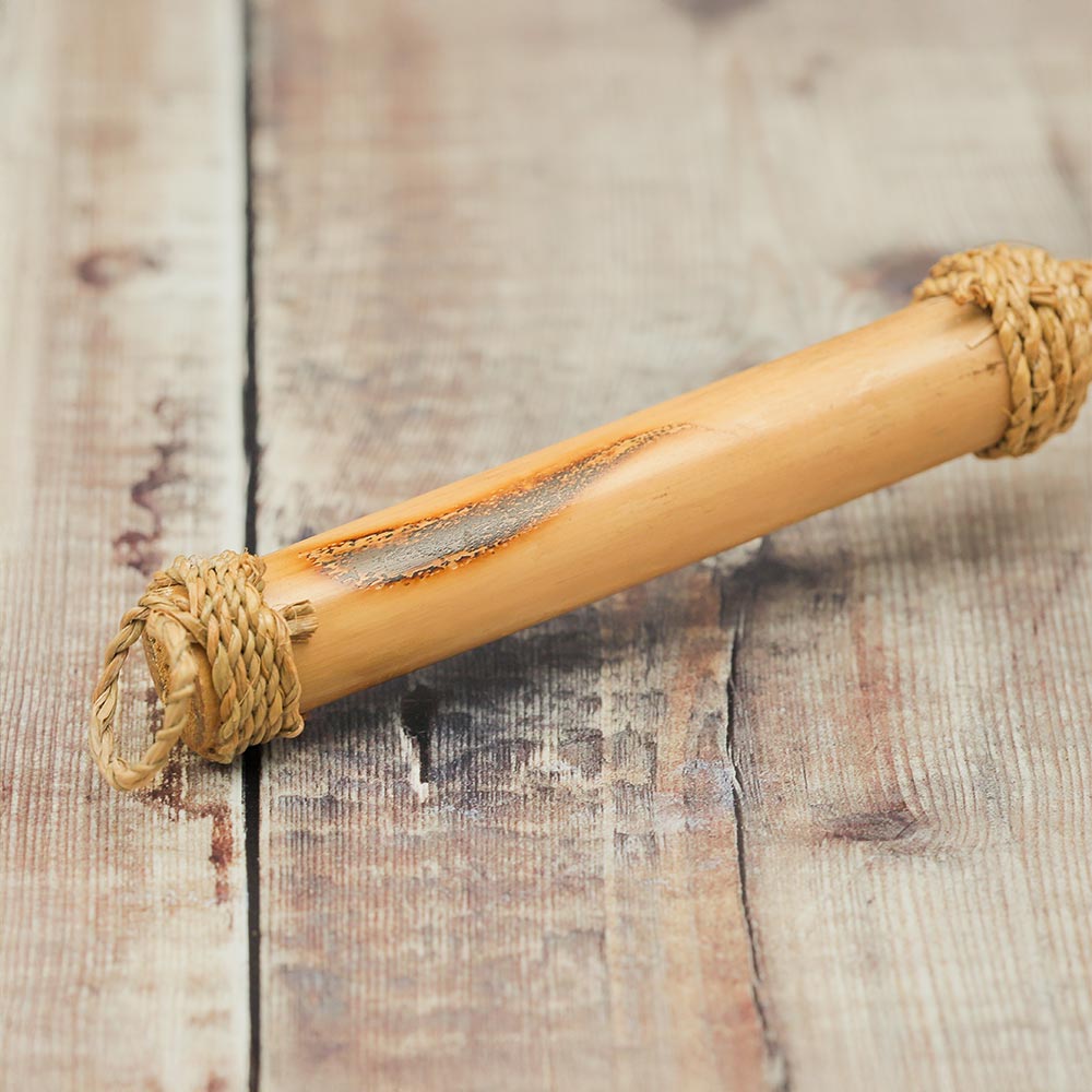 Close-up of the Klik Klak shell instrument showing the bamboo handle wrapped with jute at the bottom to form a loop.