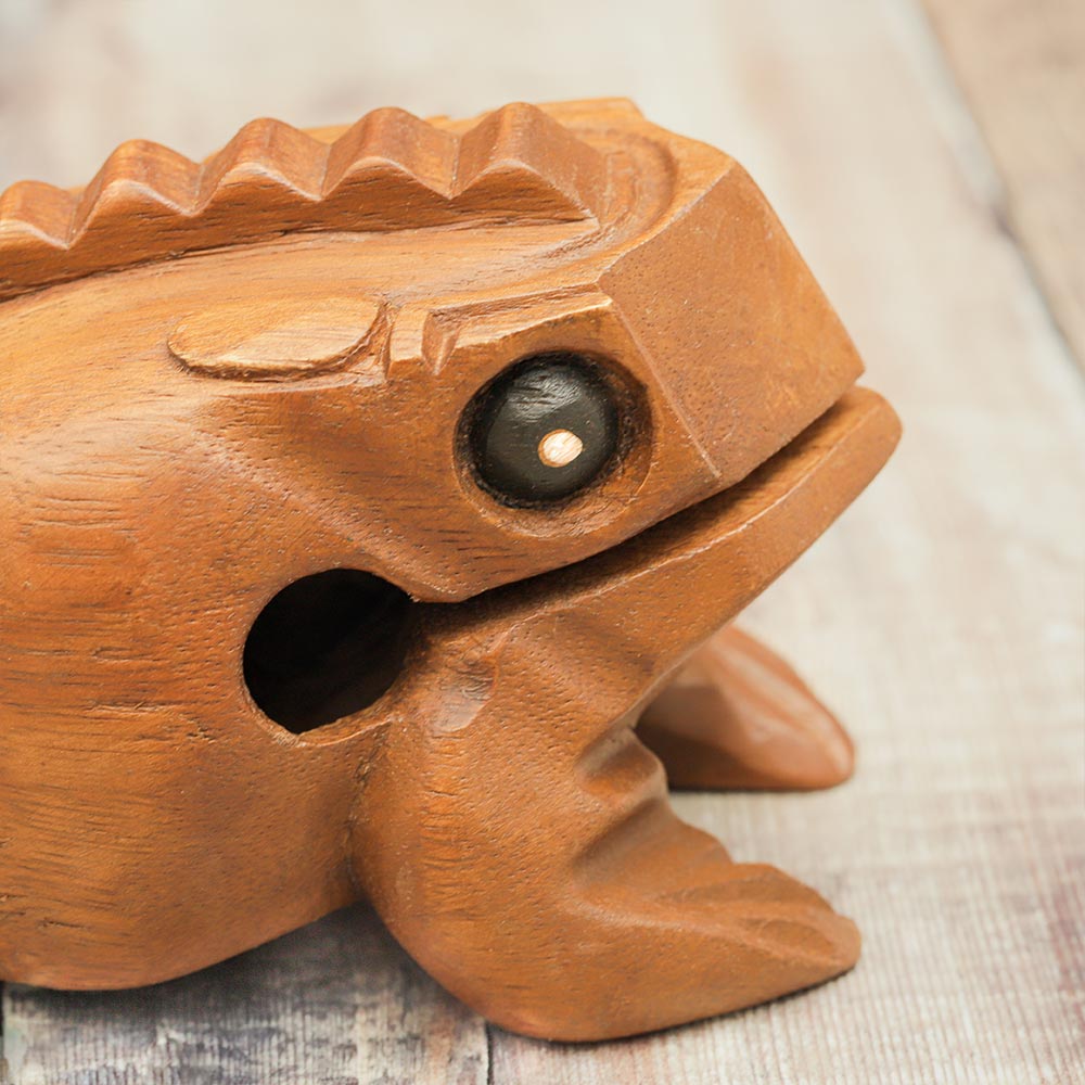 Close up of the medium croaking frog guiro showing the details of the acacia wood texture and the frog's shape.