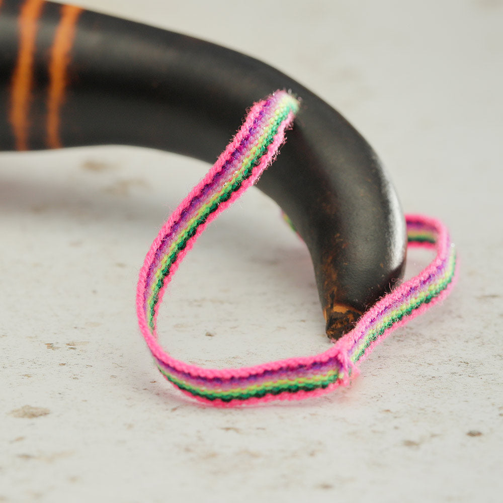 Close up of the Gourd shaker handle and pink woven ribbon