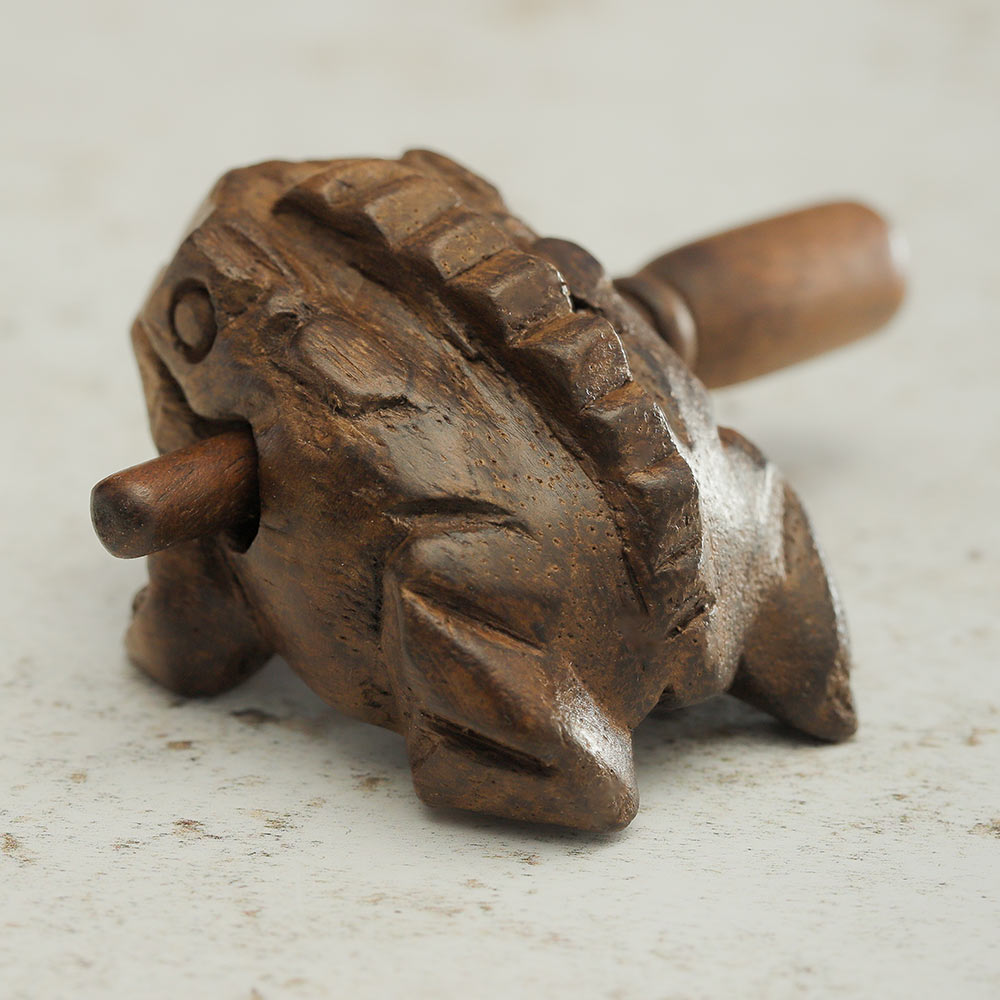 Back of the small brown wooden guiro showing close up of the ridges on its back