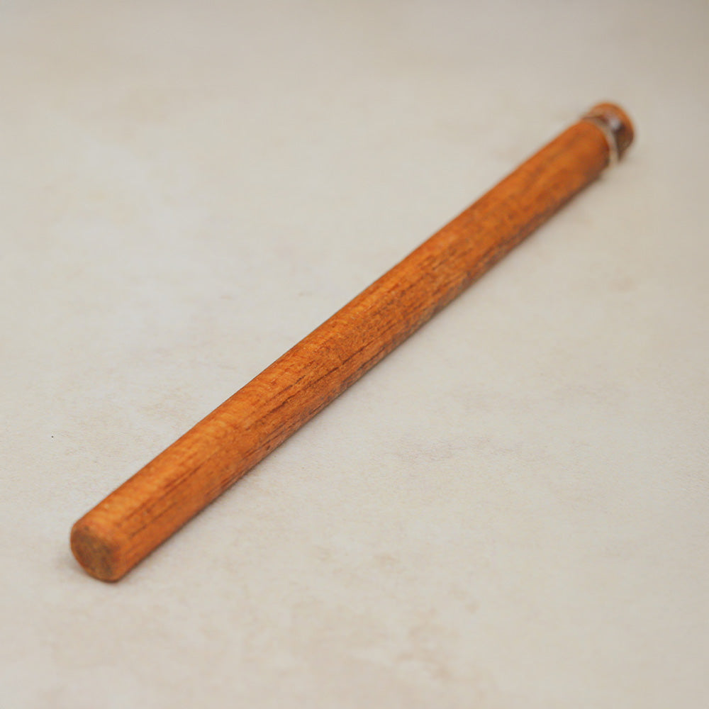Close-up of the wooden stick handle of the Croaking Goblin sound effect, highlighting the texture and design details.