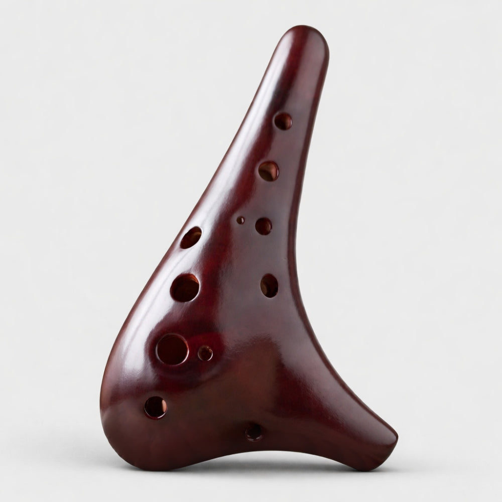 Red 12 hole ocarina on a light gray studio background