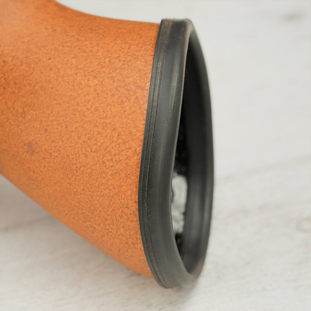 Close-up of the fibreglass shekere instrument handle showing texture and build detail.