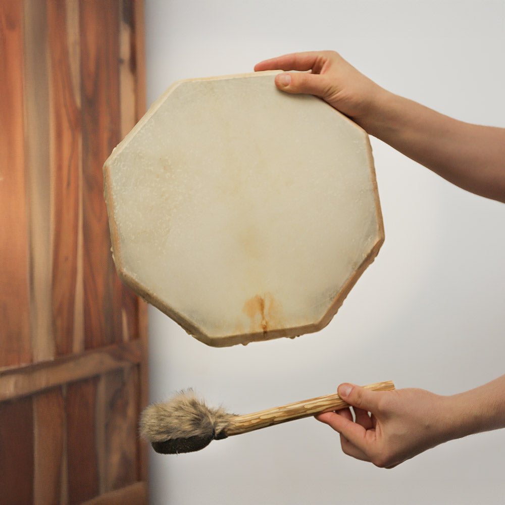 Close-up of the front of a 30cm hexagon shamanic frame drum, showcasing the smooth animal hide surface, held in hand for scale.