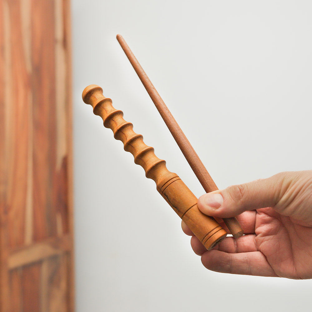 Small Jackfruit wood Pasar guiro with scraping wooden stick held in hand, demonstrating its size and design.