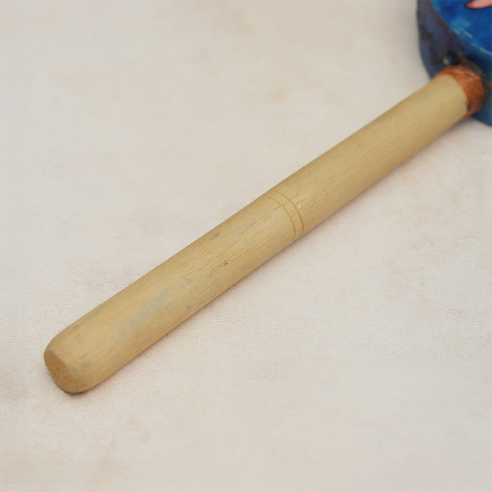Close-up of the Kumai monkey drum's wooden handle, showing its carved details and natural wood grain.