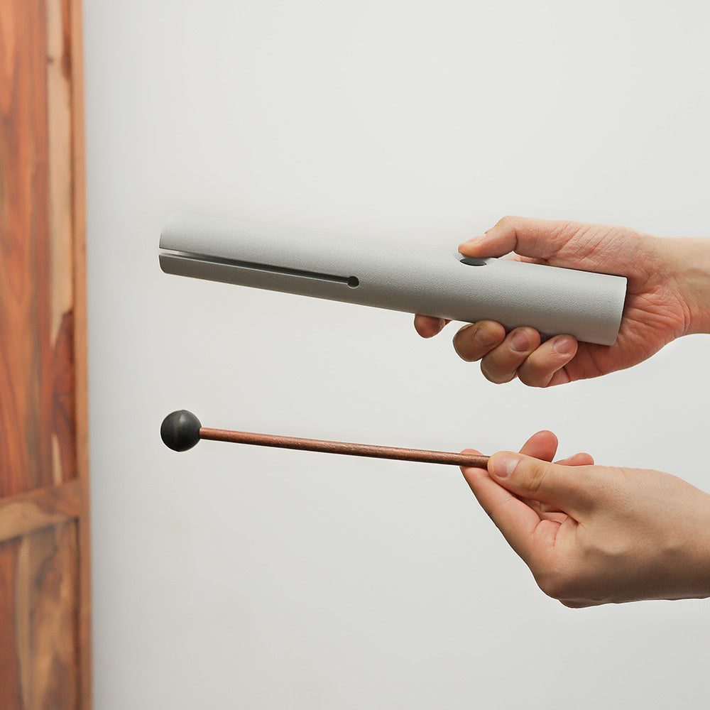Kutawapa wah-wah tube instrument held in hand, demonstrating its size and design.