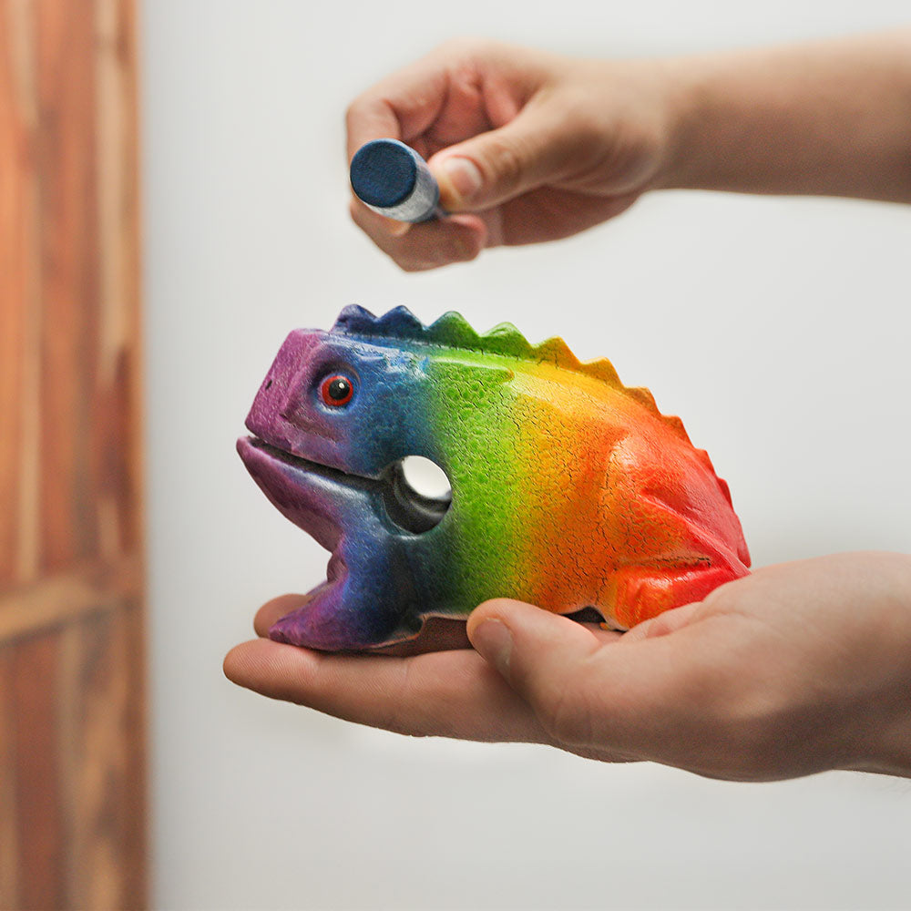 Large Pelangi rainbow coloured frog guiro instrument held in hand to show scale and size.
