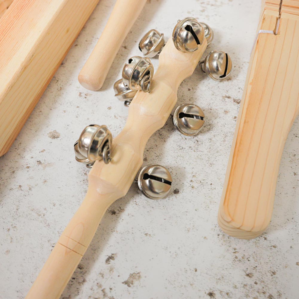 Close up of the Matsu bell shaker showing the metal stainless steel bells attached to a wooden handle
