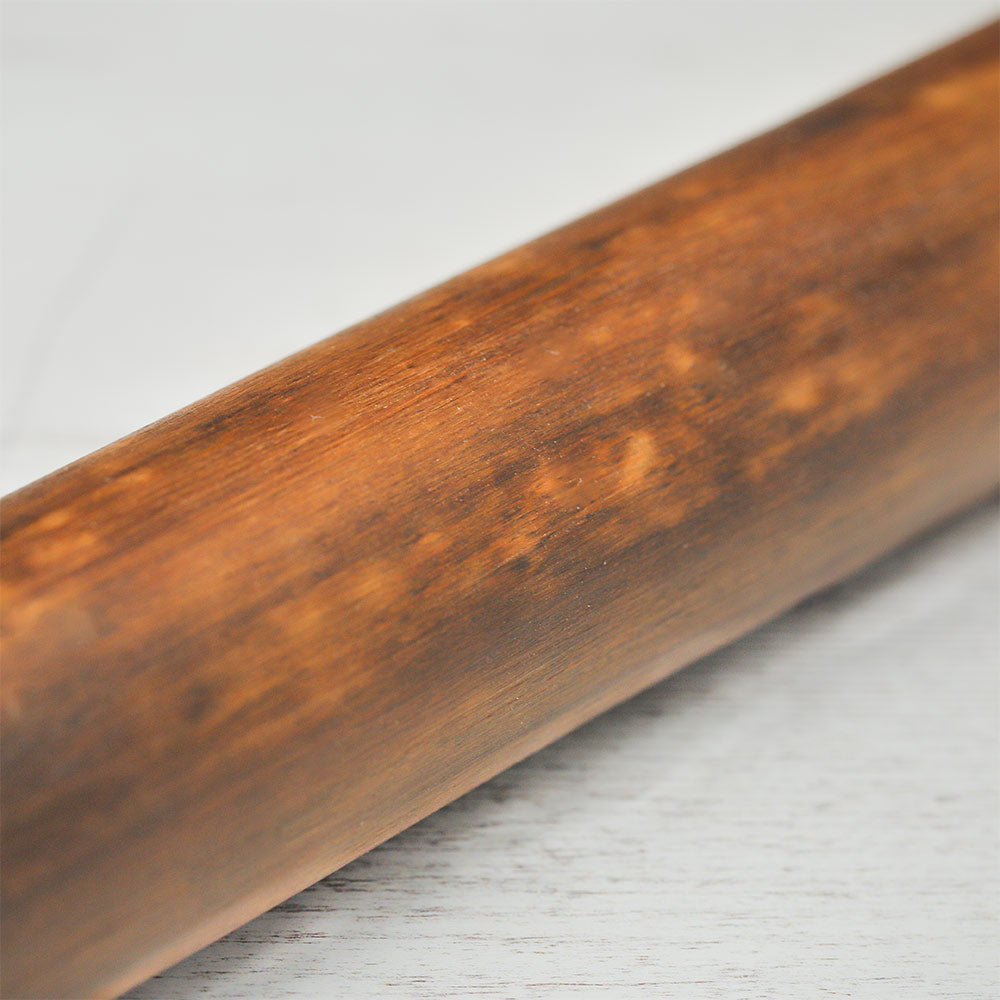 Close-up of the Painted Peruvian Rainstick showing the unpainted natural bamboo back side.