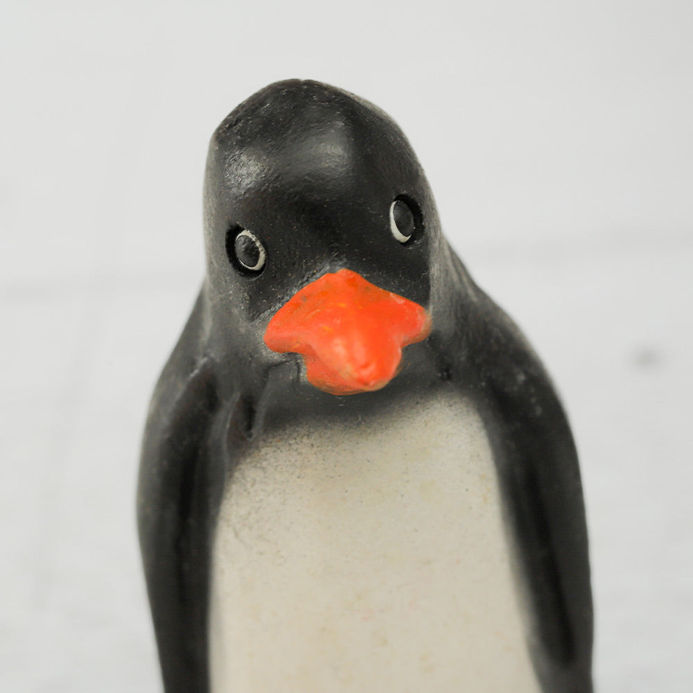 Close-up of the front of a wooden penguin ornament whistle, highlighting the detailed face.