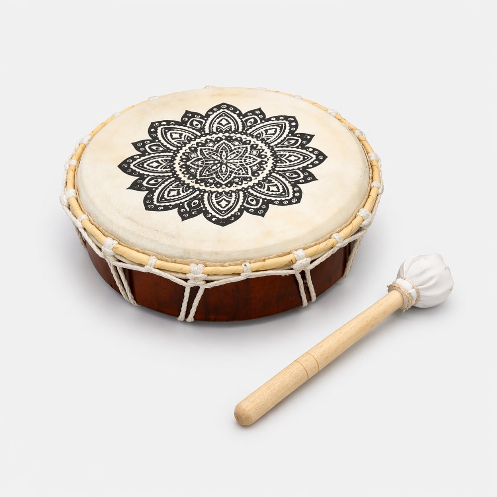 Wooden shamanic drum with mandala design and drumstick on a white background