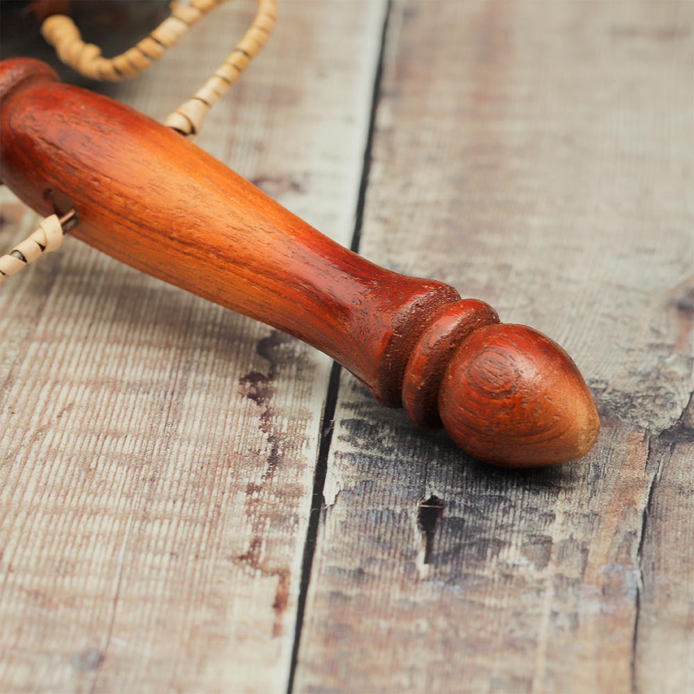 Close-up of the wooden handle of the Vietnamese Lotus clacker percussion instrument.