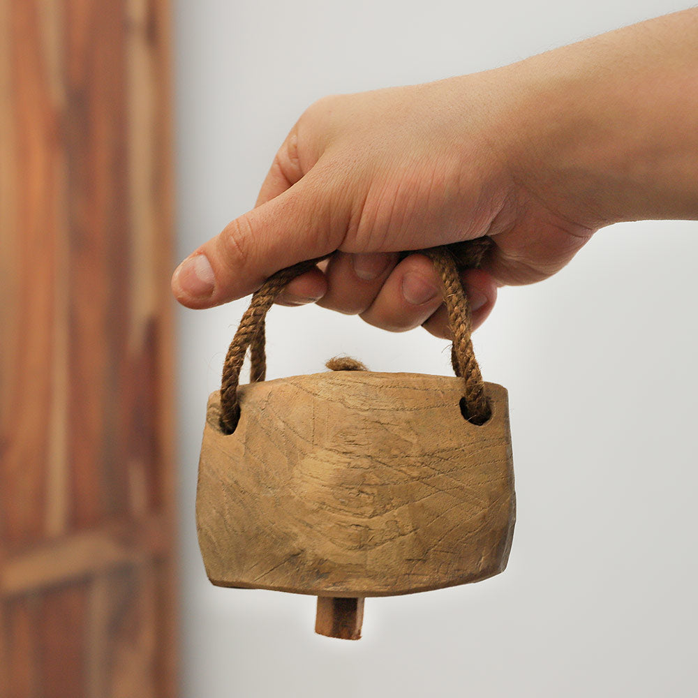 Close up of a cow  bell held in the hand, showcasing its size and scale.