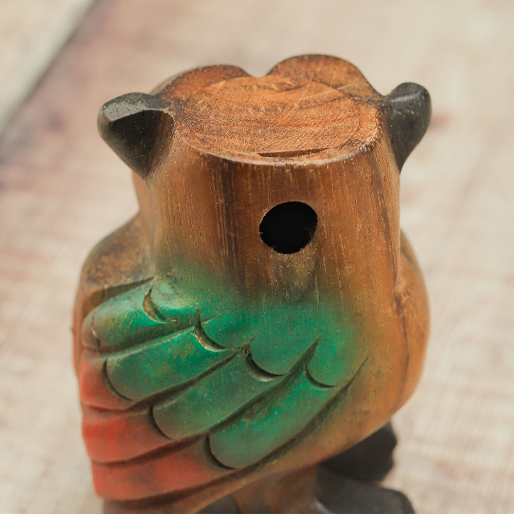 Close up of the back of the hand painted wooden hooting owl whistle showing the air hole where the sound escapes.