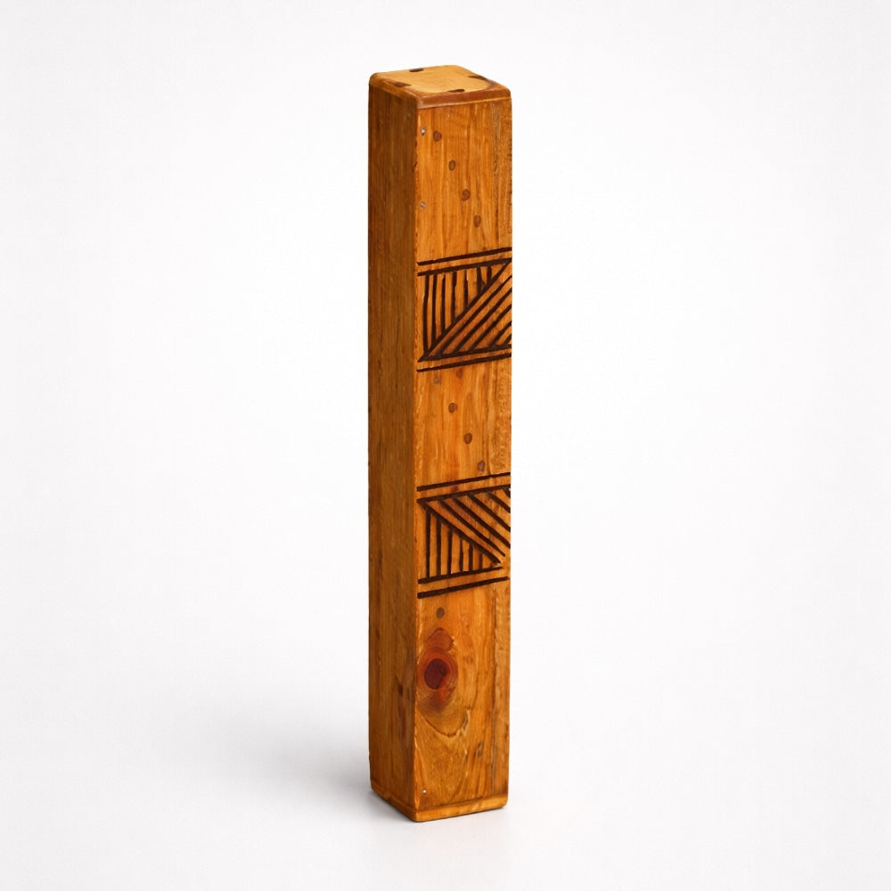 Wooden Jati Block Rainstick with geometric patterns on a white studio background