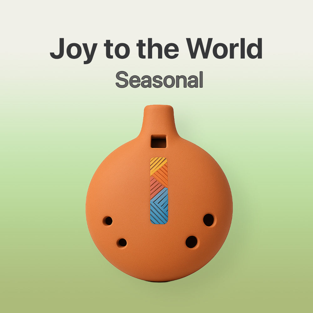 Ceramic ocarina with colorful design on a light green background, featuring text 'Joy to the World Seasonal'.