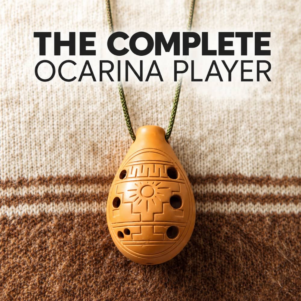 An ocarina pendant hanging from a green cord against a knitted beige and brown background, with large text at the top reading 'THE COMPLETE OCARINA PLAYER'.