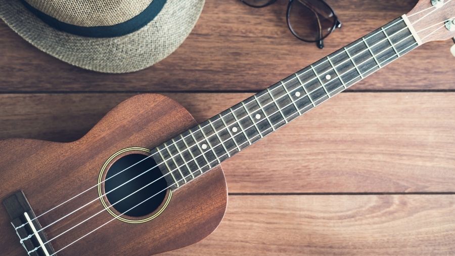 Ukulele guitar resting on a wooden table.