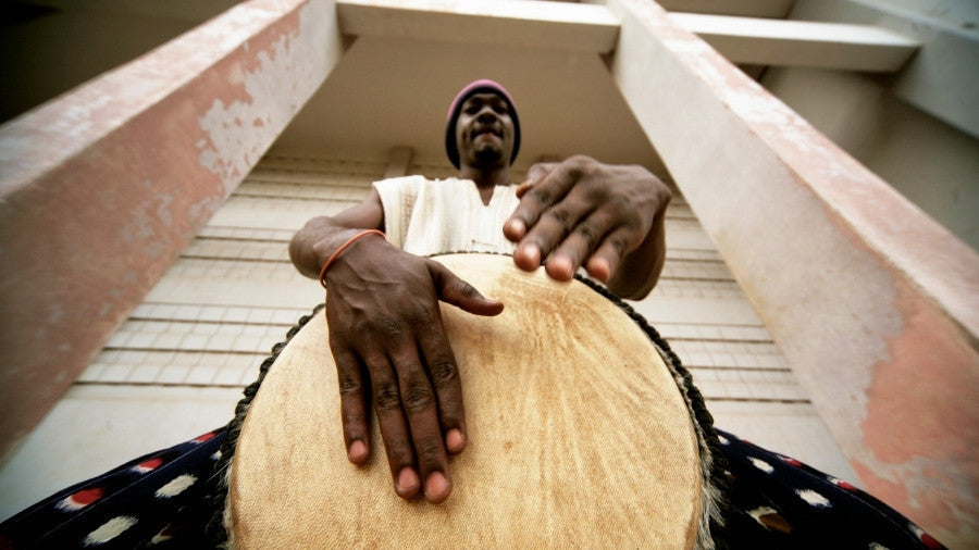 Man playing reggae music on djembe drum