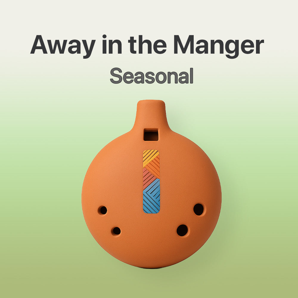 Ceramic ocarina with colorful design on a light green background, featuring text 'Away in the Manger Seasonal'.