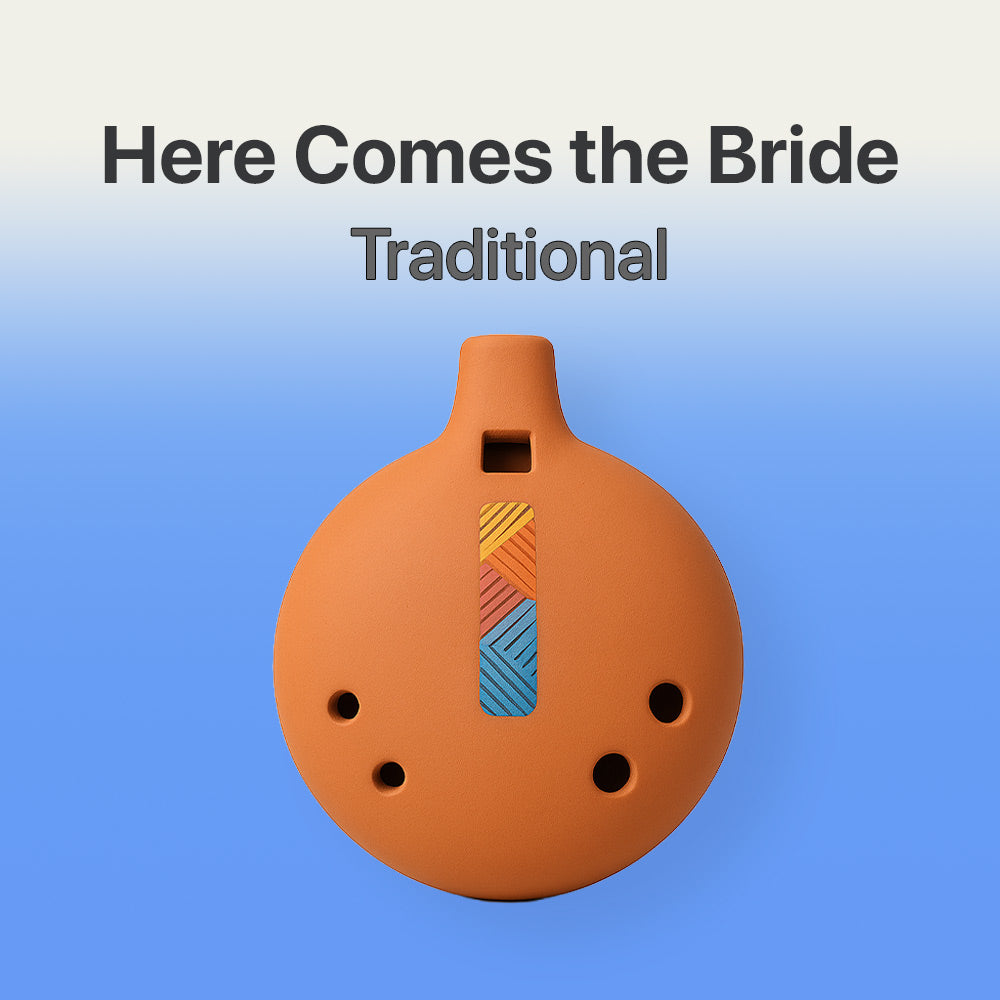 Ceramic ocarina with colorful design on a blue background, labeled 'Here Comes the Bride Traditional'.