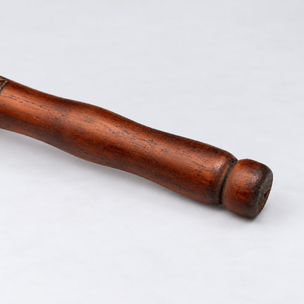 Close-up of the wooden handle of the Terre Shamanic rattle shaker, highlighting its texture and design.