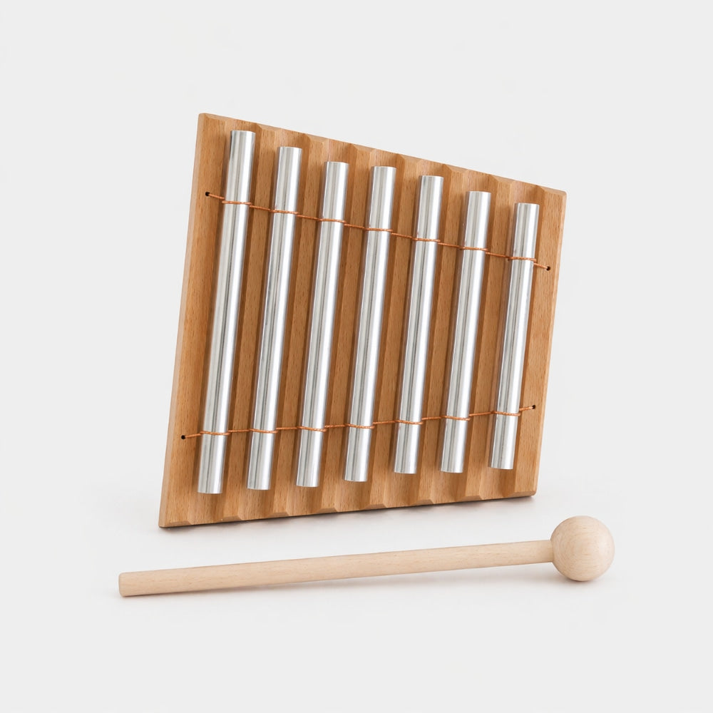 Wooden xylophone with metal bars and a wooden mallet on a white background