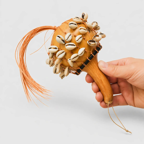 Kenyan Cowrie Calabash Shaker held in hand to show scale against a grey studio background