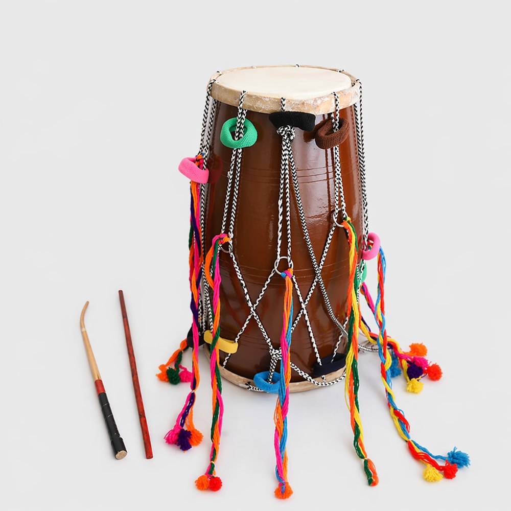 Decorative drum with colorful tassels and two drumsticks on a light gray background