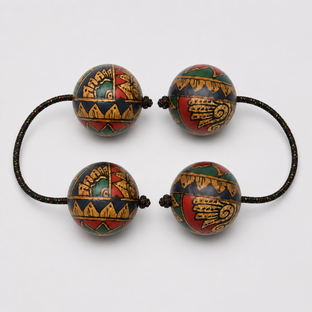 Pair of geometric kashaka shakers on a light grey studio background
