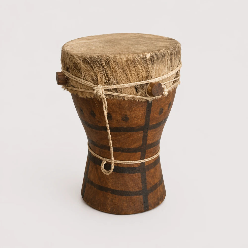A traditional Kpanlogo drum made from goatskin and wood, with tribal decorations and a rope around the top edge.