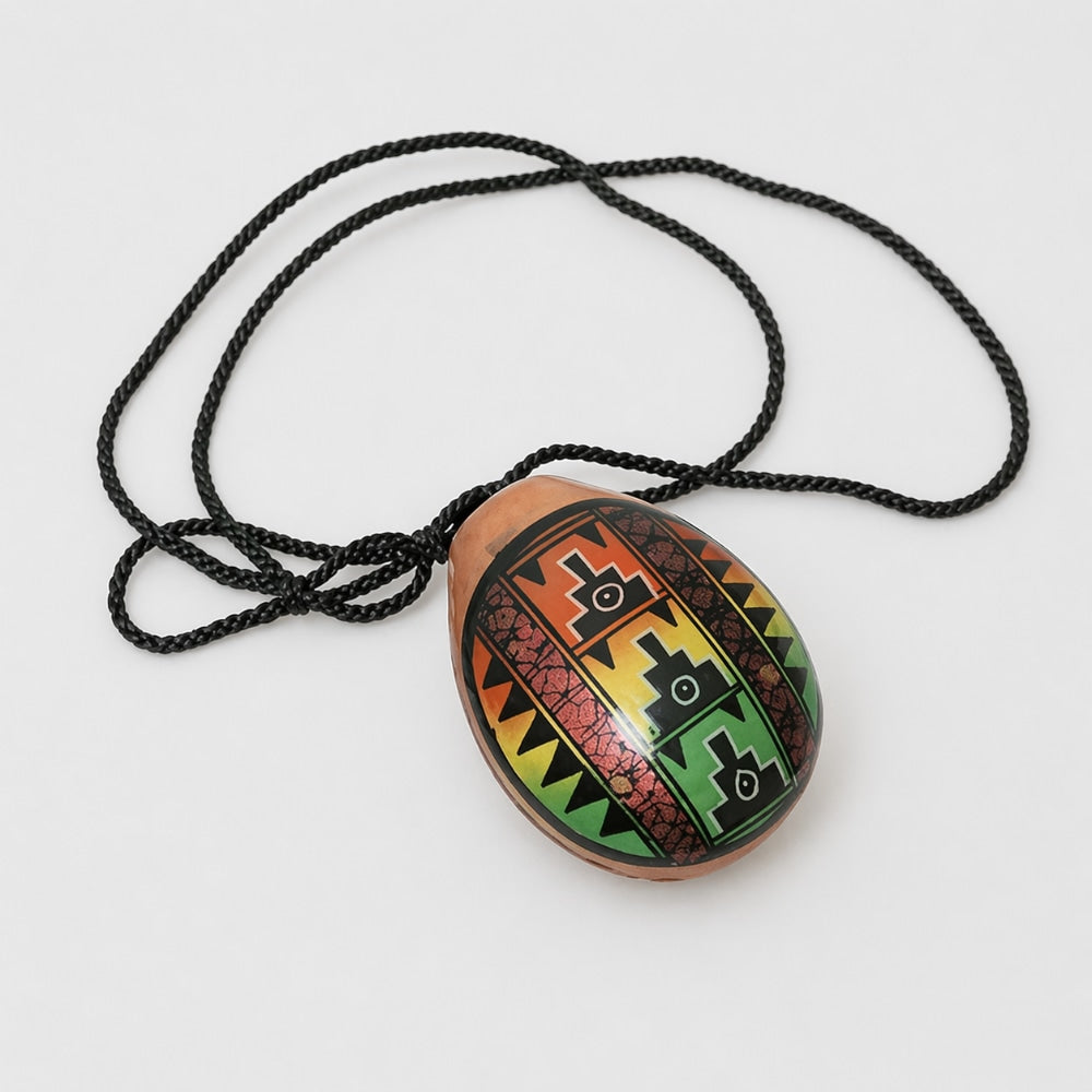 Decorative pendant with colorful patterns on a black cord against a white background