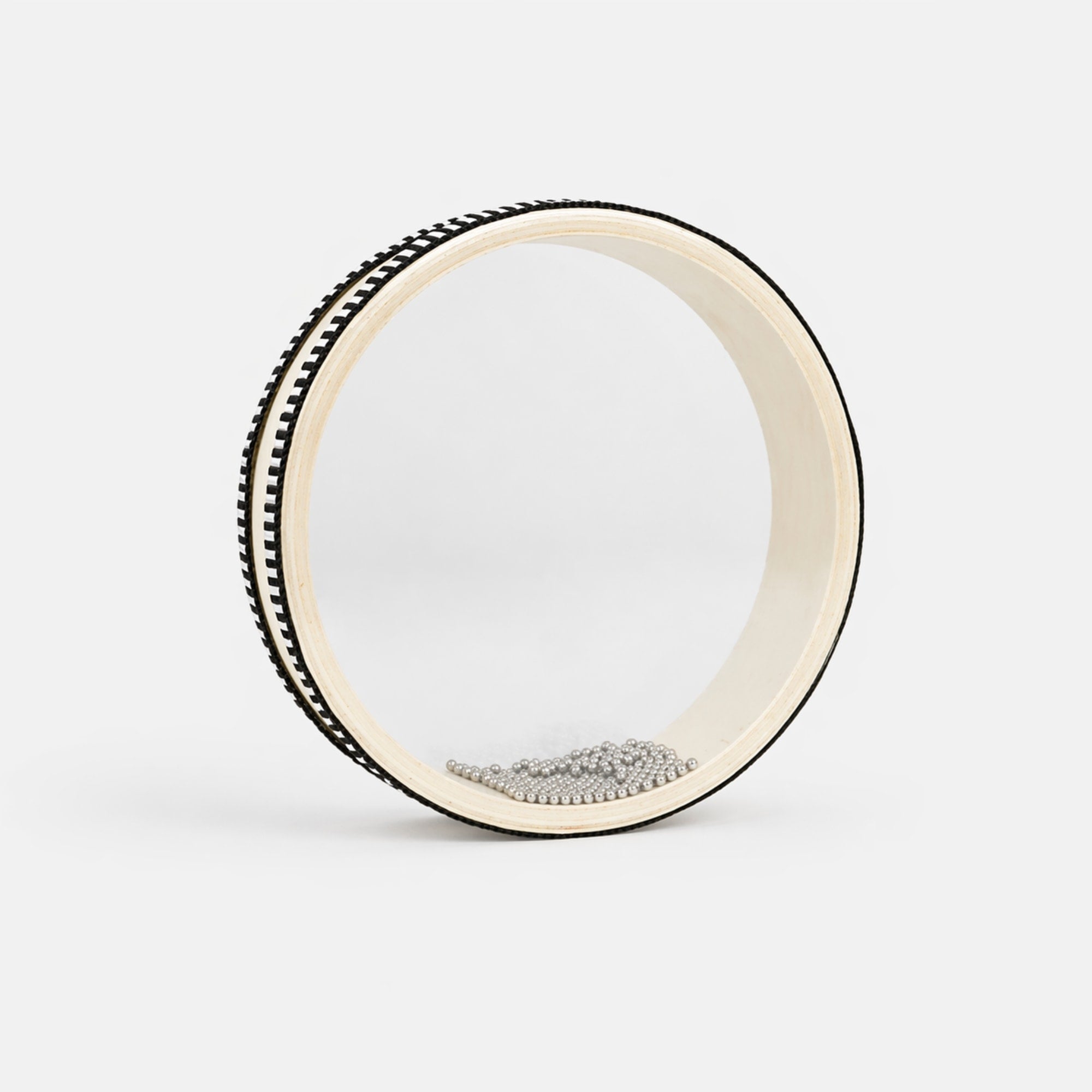 white clear ocean drum with beads on grey background 