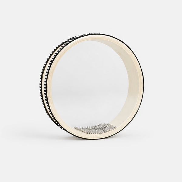 white clear ocean drum with beads on grey background 