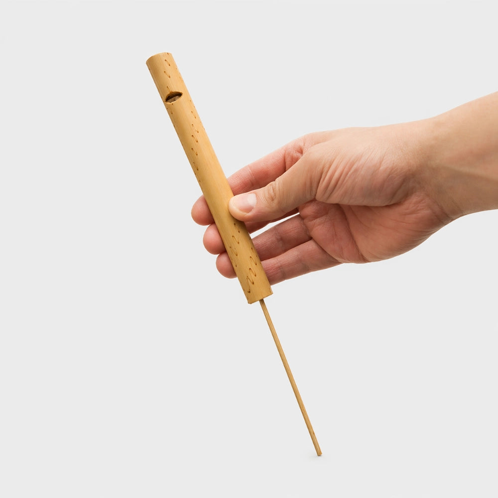 Indonesian bamboo whistle (large) held in hand, demonstrating its size and design.