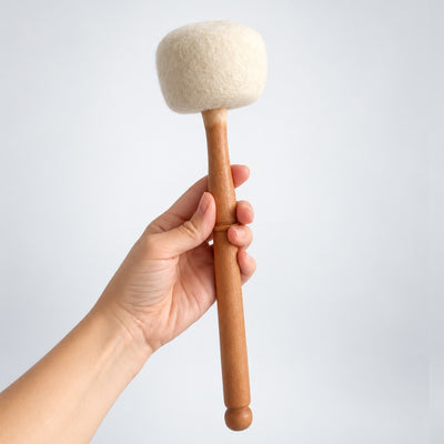 hand holding wooden and wool mallet