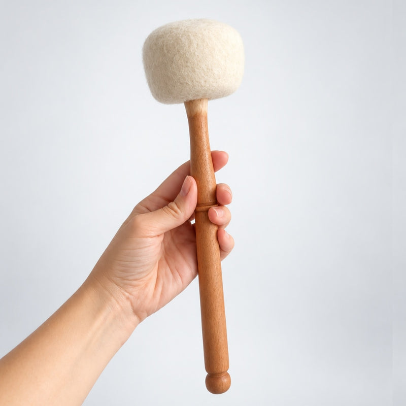 hand holding wooden and wool mallet